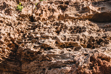 Brown wall texture. Stone background. Rock texture. Grunge Rough structure. Abstract texture. Rock surface with cracks. Rock pile. Paint spots.