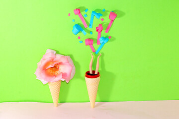 ice cream cone with pink flower and ice cream cone with hands throwing confetti, creative summer party design on green pink background