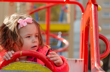 Two-year-old Beautiful Little Girl playing on the Playground in the city