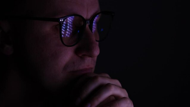 Male Working Online Late. Close Up Side View Of Focused Man Wears Computer Glasses For Reducing Eye Strain Blurred Vision Looking At Pc Screen With Computer Reflection Using Internet, Watching.