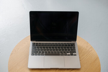 Thin laptop on wooden table and gray background.