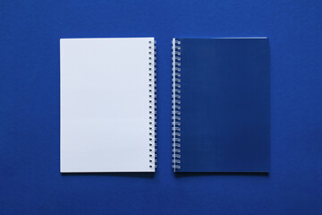 Minimal workspace with blue notebook layout and stationery on blue background. School concept. Office concept.