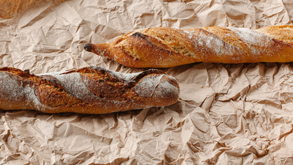Two loaves close up on a brown kraft paper background. Culinary background, top view. Place for text.