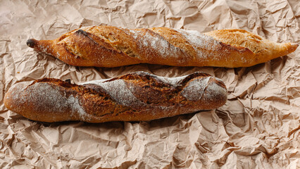 Two loaves close up on a brown kraft paper background. Culinary background, top view. Place for text.
