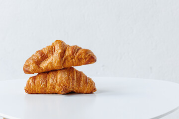 Two juicy golden croissants on a white background with space for design.