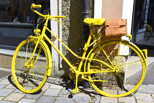 Leuchtend gelbes Fahrrad an einer Hauswand