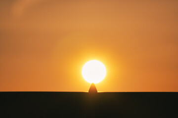 silhouette of a person holding a sun
