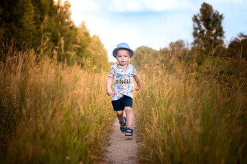 Dziecko biegnące po polnej ścieżce  - obrazy, fototapety, plakaty