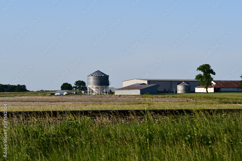 Poster silos and barns in a farm field