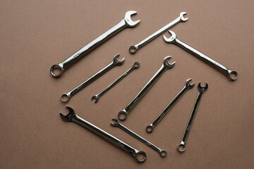 Wrenches of different sizes on a brown background. Top view.