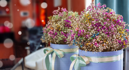 flowers in a box with ribbons in on a table, a delicate bouquet of multicolored gypsophila as a present for Easter