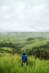 Fototapeta na wymiar Man standing in middle of green hills. West Kalimantan.