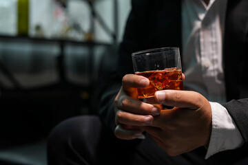 Closeup businessmen holding a glass of whiskey