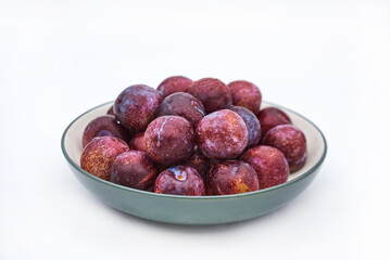 Purple plums on white background