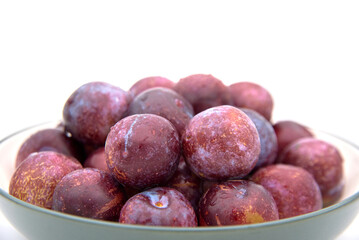 Purple plums on white background