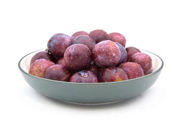 Purple plums on white background