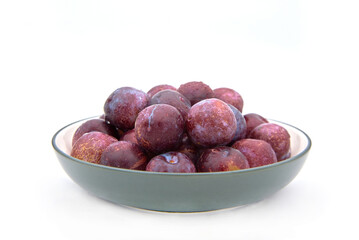 Purple plums on white background