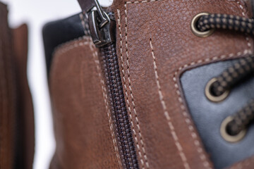 Fragment of fashionable men's brown winter boot made of genuine leather with fur.