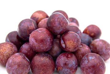 Purple plums on white background