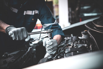 Car care maintenance and servicing, Close-up hand technician auto mechanic using the wrench to...