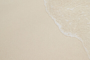 Close Up soft wave flow beautiful ocean on sandy beach. Background. sunshine in the evening. top view.