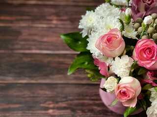 Vintage wooden surface, A part of beautiful bouquet with different flowers in a round box on a wooden brown textured background. Concept of greeting or invitation card. Thank you card, copy space