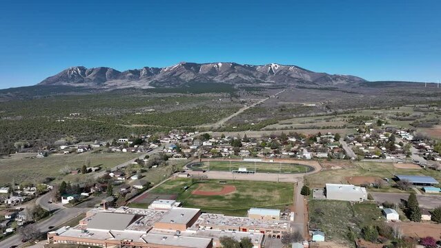 Aerial Monticello Utah rural neighborhood pull part 3. Settled in July 1887 by pioneers from The Church of Jesus Christ of Latter-day Saints. Farming, ranching, and uranium mining. Mountain valley.