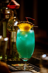 Glass of Blue Hawaii Cocktail on Wooden Bar Counter