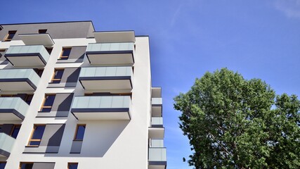 Apartment building with bright facades. Modern minimalist architecture with lots of square glass windows and balconies.