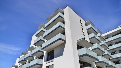 Apartment building with bright facades. Modern minimalist architecture with lots of square glass windows and balconies.