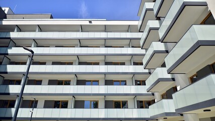 Apartment building with bright facades. Modern minimalist architecture with lots of square glass windows and balconies.