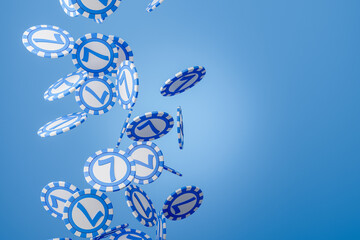 Casino poker chips falling on blue background. Copy space