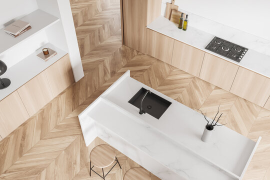 Top view of light kitchen interior with island, drawer and kitchenware