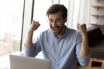 Happy surprised businessman excited with good news, using laptop, looking at screen, getting awesome good news, celebrating win, job result, achieve, approved loan. Employee getting job promotion.