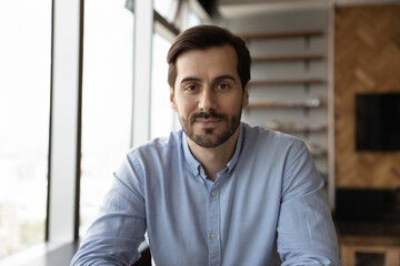 Head shot of confident friendly business professional looking at camera during online virtual...