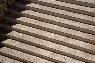 a concrete staircase on a sunny day that forms an interesting pattern with a shadow on the left side
