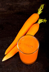 Fresh squeezed carrot juice on wooden table