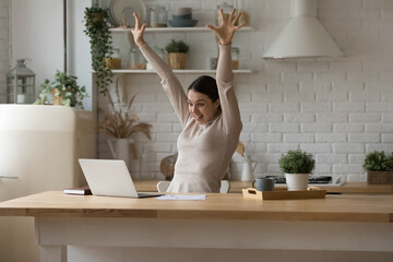 Overjoyed crazy freelancer girl getting great happy news at laptop, staring at display, making winner hands in amazement, celebrating success, luck, achieve, good result, win