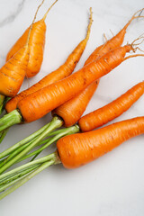 Close up of ripe carrots roots on light surface