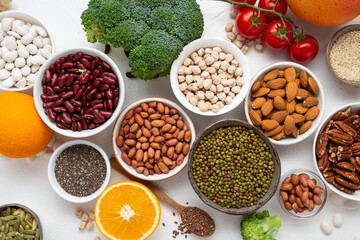 raw beans seeds nuts vegan food and vegetables on light surface
