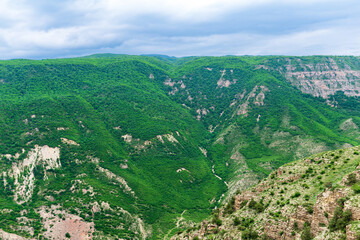 Fototapeta na wymiar mountain landscape, view of a huge gorge with rocky green slopes