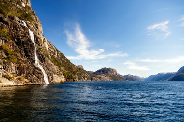 Naklejka premium View of Norwegian waterfall cascading into Lysefjorden fjord