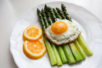 asparagus, lemon and scrambled eggs on a white dish. table setting