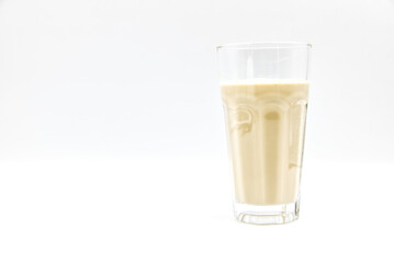 Coffee flavored milk in a glass on a white background..