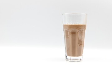 Chocolate milk in a glass on a white background.