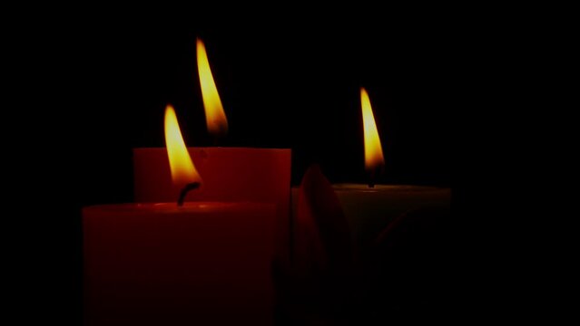 Close up Candles Flame Gently Swaying In The Wind. Burning Candles In The Dark Rotated.