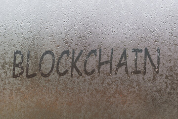 blockchain handwritten on wet glass of night window