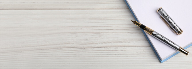 Beautiful fountain pen and notebook on white wooden table, top view with space for text. Banner design - Powered by Adobe