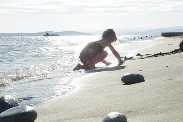 Toddler girl playing at the sand beach