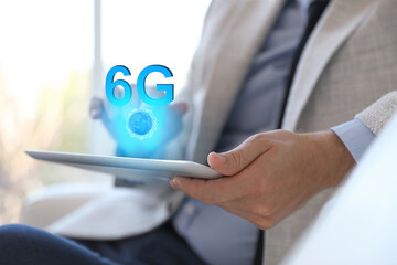 Man using tablet with 6G network system indoors, closeup